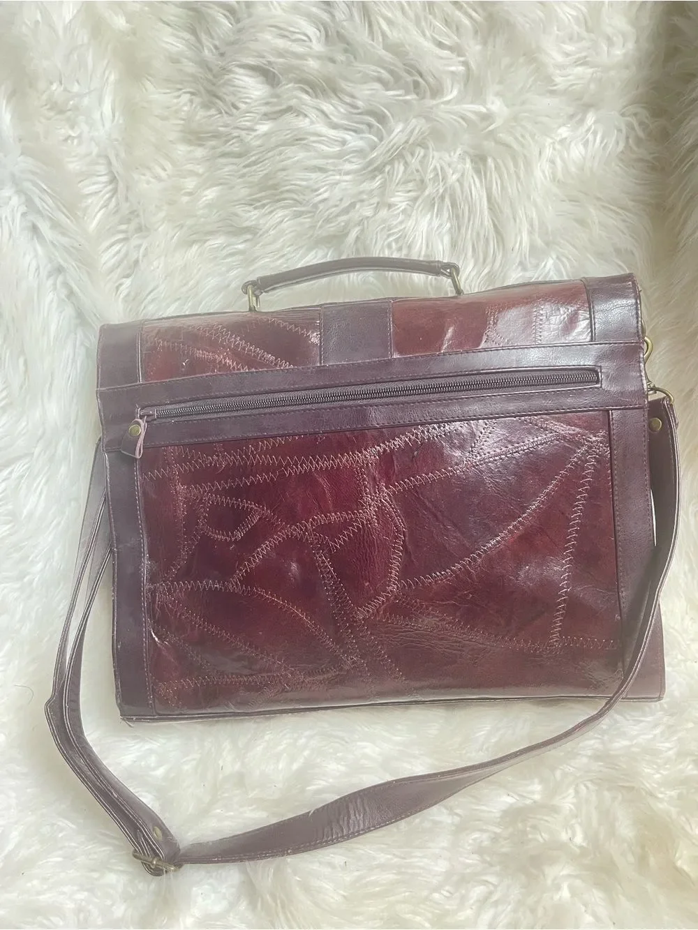 M.C textured leather patchwork like stitched accent burgundy leather bag .